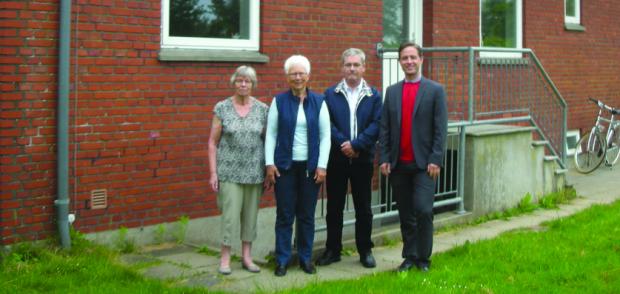 Marie Bertelsen, Lis Møller og  Ole Schultz sammen med skolens  rektor ­Timothy Veale foran nedgangen  til ­arkivet.